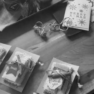 Bild von Frauenhausaktion Nahaufnahme Geschenk Mitarbeiter: Geschenkpakete und Weihnachtskarten auf einem Tisch, vorbereitet für das Fest.