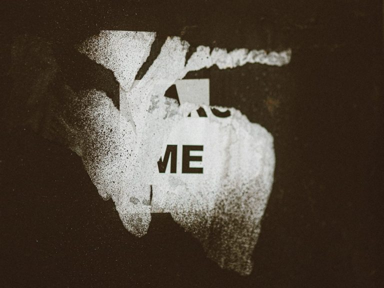 Kunstvolles, dunkles Bild mit dem Schriftzug „ME“ in der Mitte.