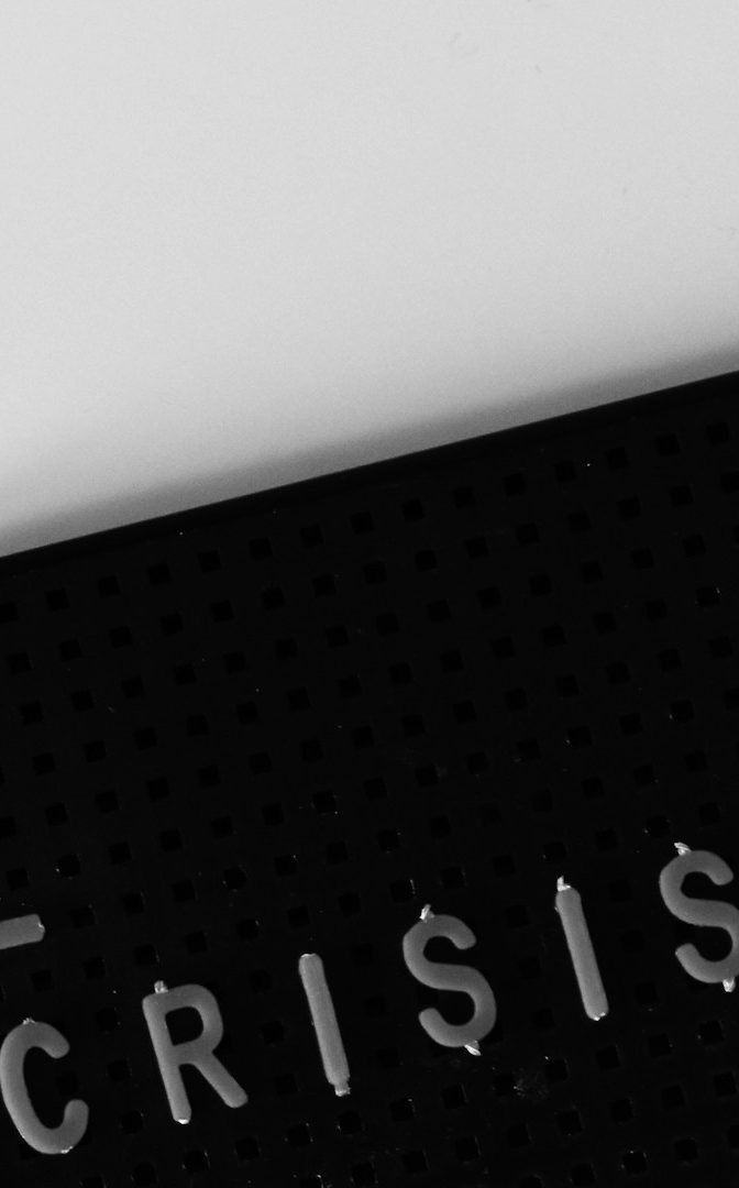 Text auf schwarzem Hintergrund: "CRISIS" in weißen Buchstaben.